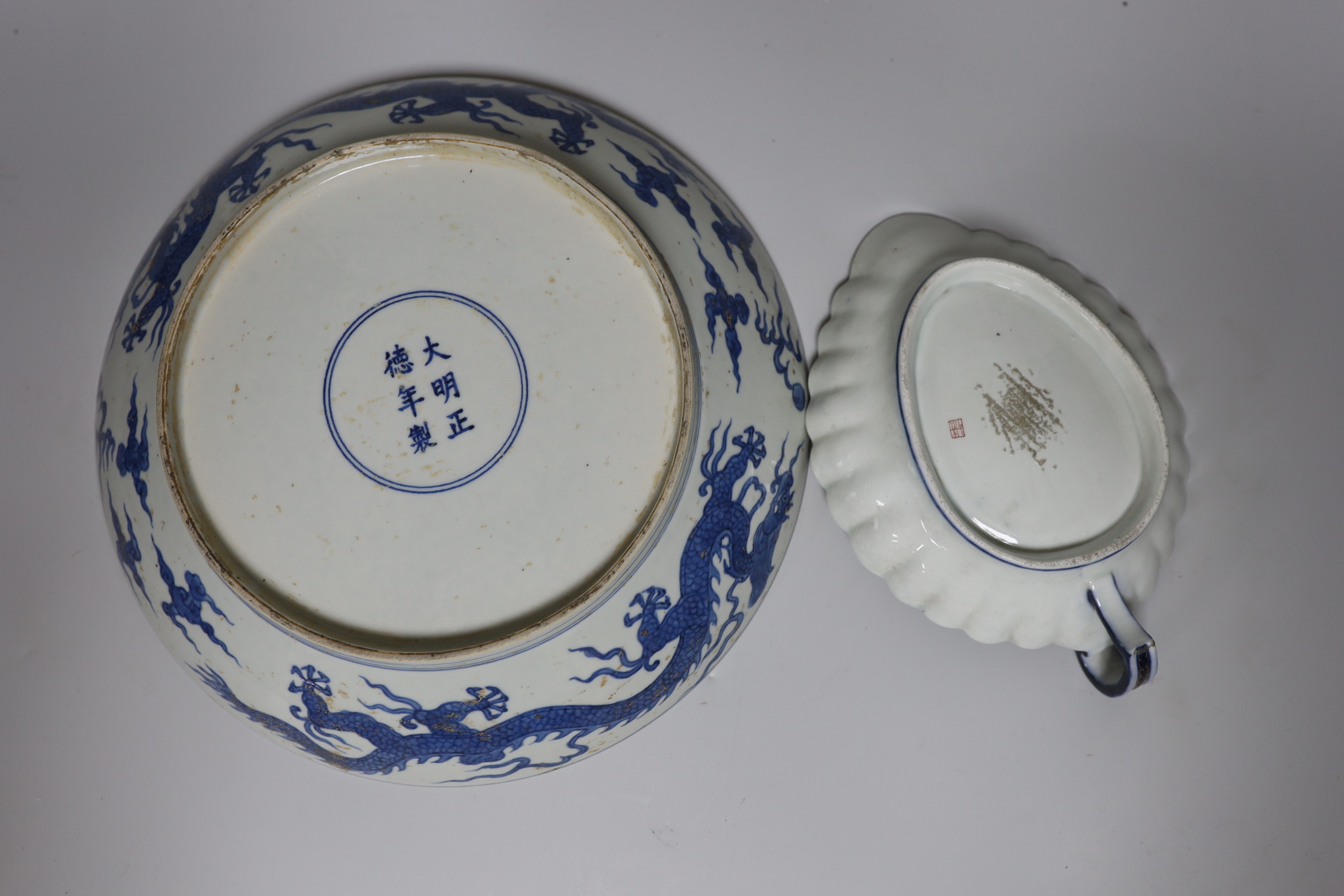 A Chinese blue and white ‘dragon’ dish, marked to base, 28cm diameter, together with a Samson blue and white ground serving dish with gilt decoration